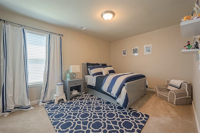 bedroom featuring light carpet and a textured ceiling