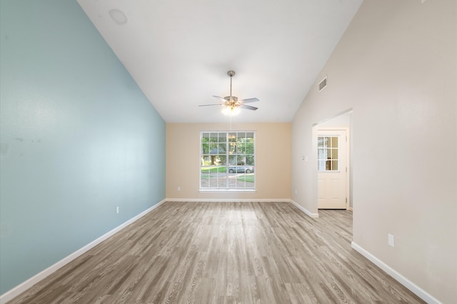 empty room with ceiling fan, light hardwood / wood-style flooring, and vaulted ceiling