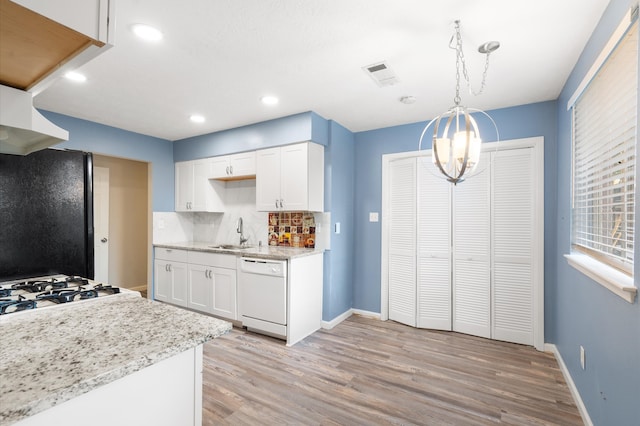 kitchen with white cabinetry, dishwasher, pendant lighting, light hardwood / wood-style flooring, and black fridge