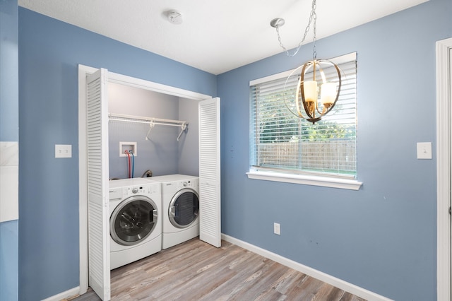 washroom featuring light wood-type flooring, independent washer and dryer, and a chandelier