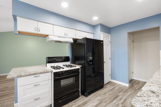 kitchen with light wood-type flooring, black appliances, white cabinetry, and light stone counters