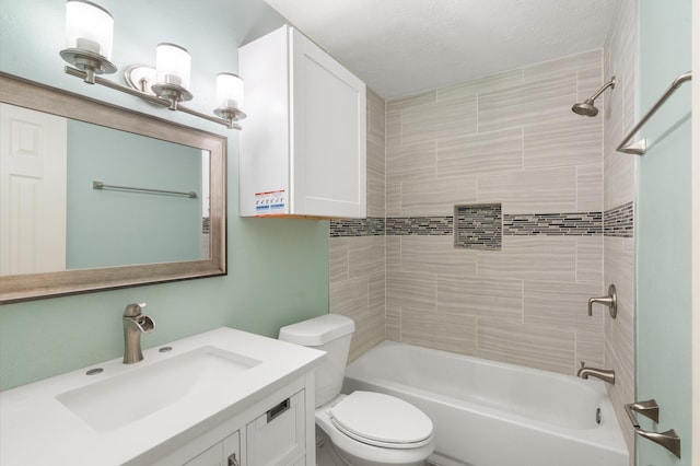 full bathroom with tiled shower / bath, vanity, toilet, and a textured ceiling