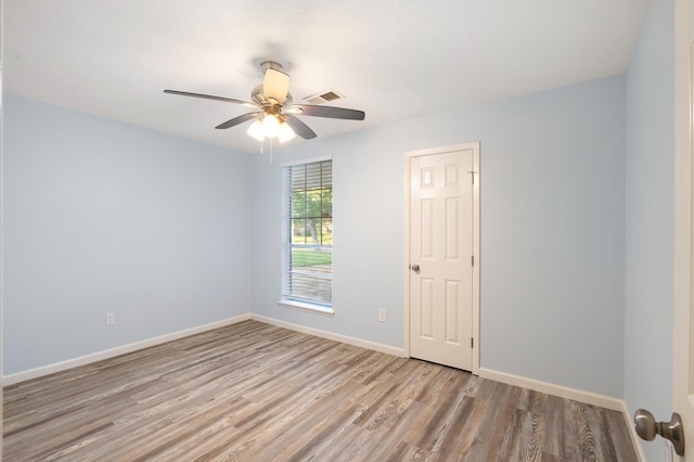 spare room featuring light hardwood / wood-style floors and ceiling fan