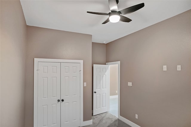 unfurnished bedroom with ceiling fan, light colored carpet, and a closet