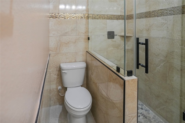 bathroom featuring a tile shower, tile walls, and toilet