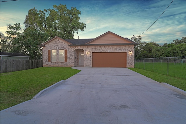 ranch-style home featuring a garage and a yard