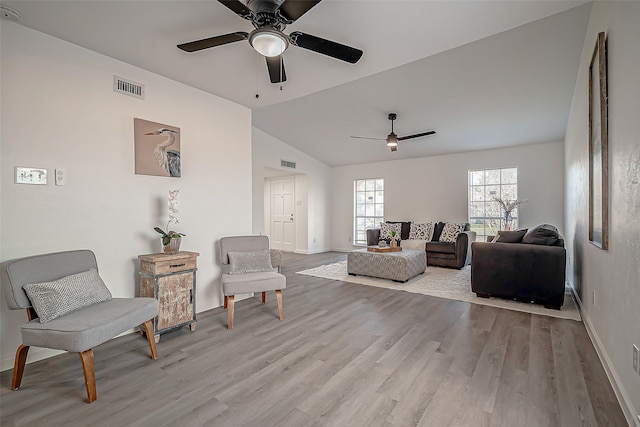 living room featuring light hardwood / wood-style flooring, vaulted ceiling, and ceiling fan