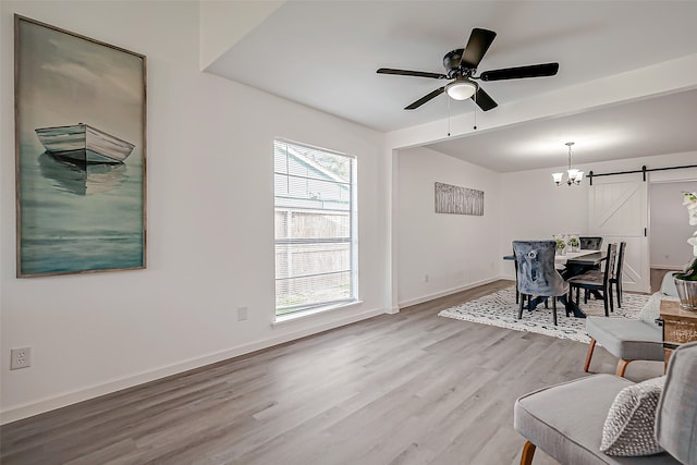 dining area with ceiling fan, hardwood / wood-style flooring, and a barn door