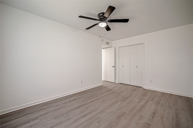 unfurnished bedroom with ceiling fan, a closet, and light hardwood / wood-style floors