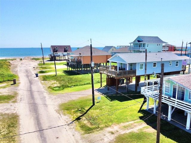 view of property's community with a water view, a yard, and a beach view