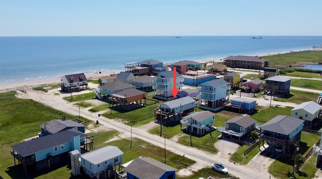 birds eye view of property featuring a water view and a beach view