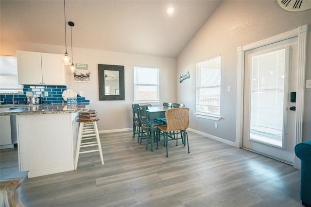 dining space with lofted ceiling and dark wood-type flooring