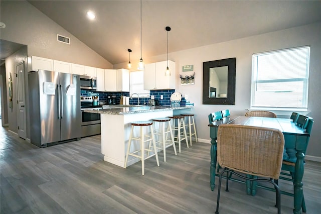 kitchen featuring white cabinetry, appliances with stainless steel finishes, pendant lighting, and kitchen peninsula