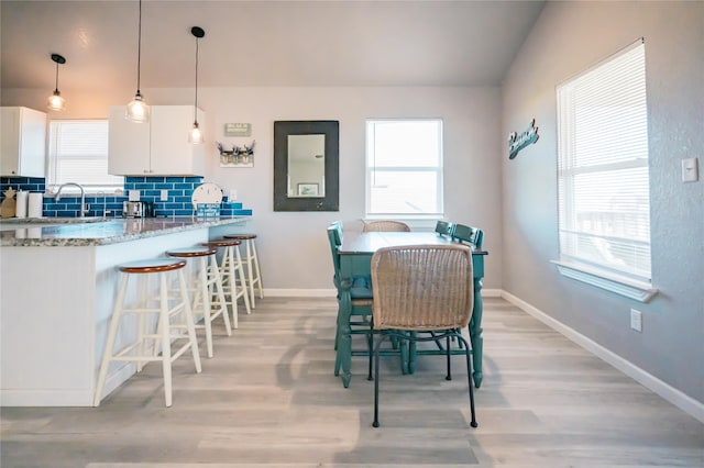 dining area with plenty of natural light, sink, and light hardwood / wood-style flooring