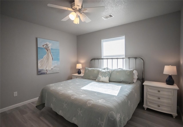 bedroom featuring a textured ceiling, dark wood-type flooring, and ceiling fan