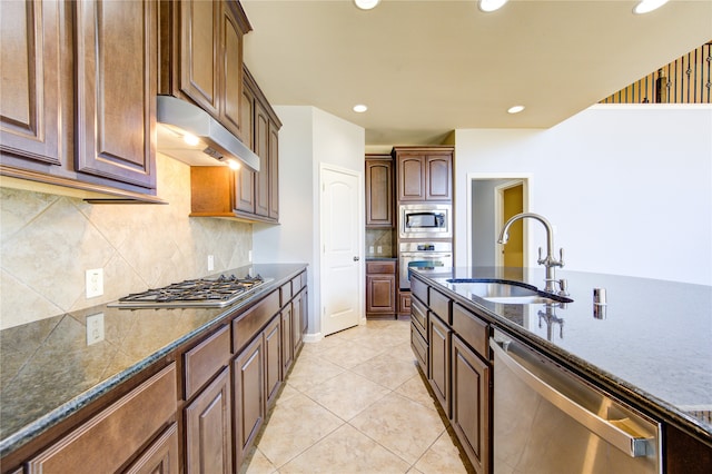 kitchen with decorative backsplash, sink, light tile patterned floors, and stainless steel appliances