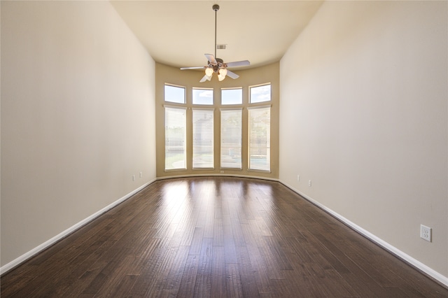 unfurnished room featuring dark wood-type flooring and ceiling fan