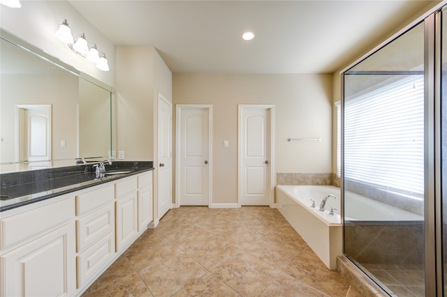 bathroom featuring plus walk in shower, tile patterned flooring, and vanity