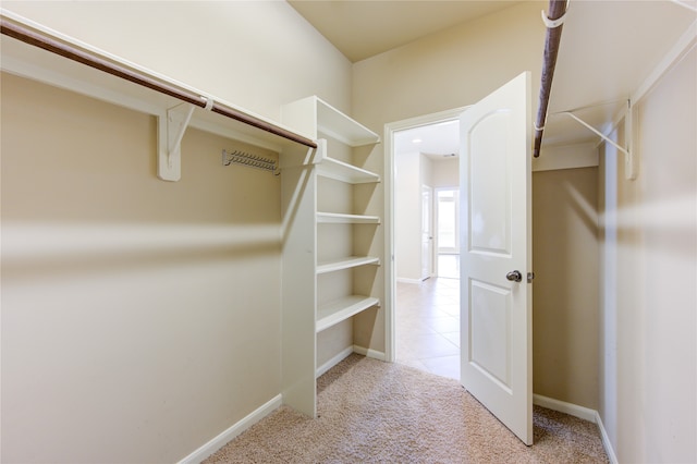 walk in closet featuring light carpet