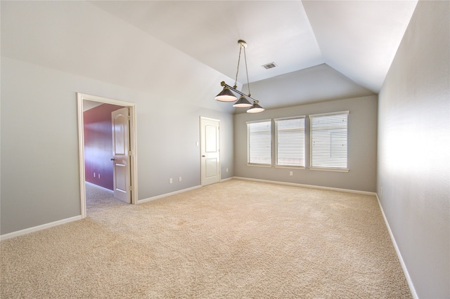 spare room with light carpet and vaulted ceiling