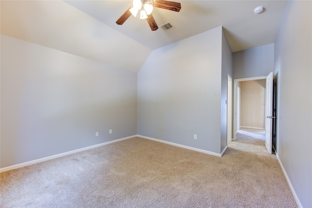 interior space featuring lofted ceiling, ceiling fan, and light colored carpet