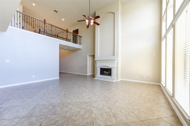 unfurnished living room featuring high vaulted ceiling, ceiling fan, and light tile patterned floors