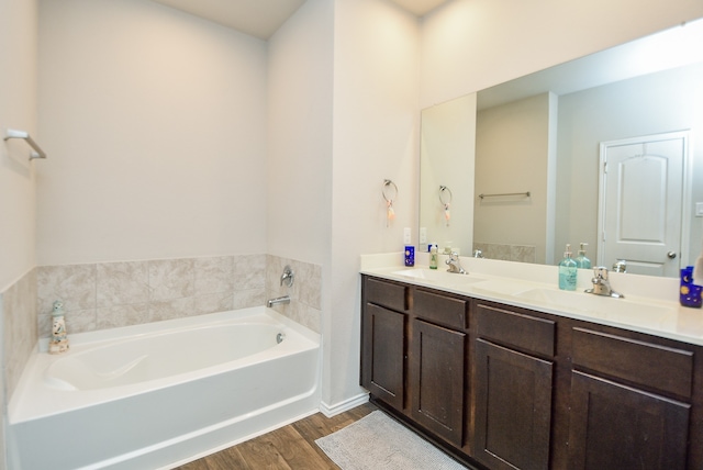 bathroom featuring wood-type flooring, vanity, and a tub to relax in