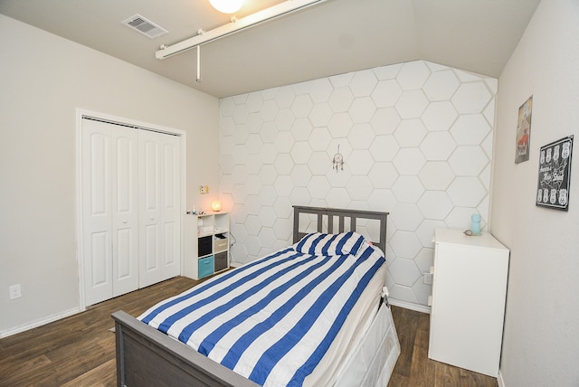 bedroom with tile walls, a closet, and dark hardwood / wood-style floors