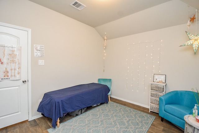 bedroom with vaulted ceiling and dark hardwood / wood-style floors