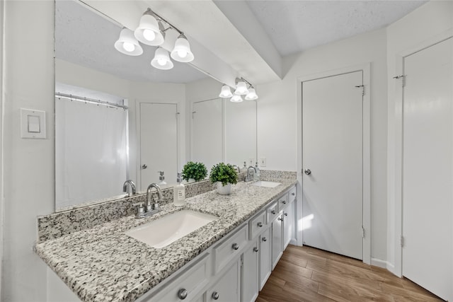 bathroom featuring a textured ceiling, vanity, hardwood / wood-style floors, and an inviting chandelier