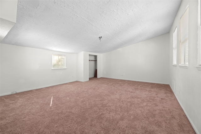 spare room featuring lofted ceiling, a textured ceiling, and carpet floors