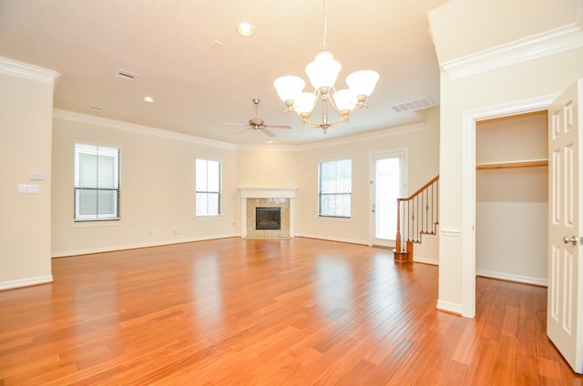 unfurnished living room with wood-type flooring, crown molding, and a healthy amount of sunlight