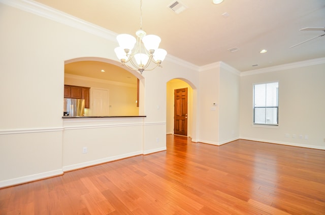 spare room featuring ceiling fan with notable chandelier, light wood-type flooring, and crown molding