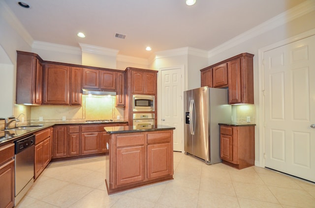 kitchen with light tile patterned floors, sink, appliances with stainless steel finishes, a center island, and crown molding