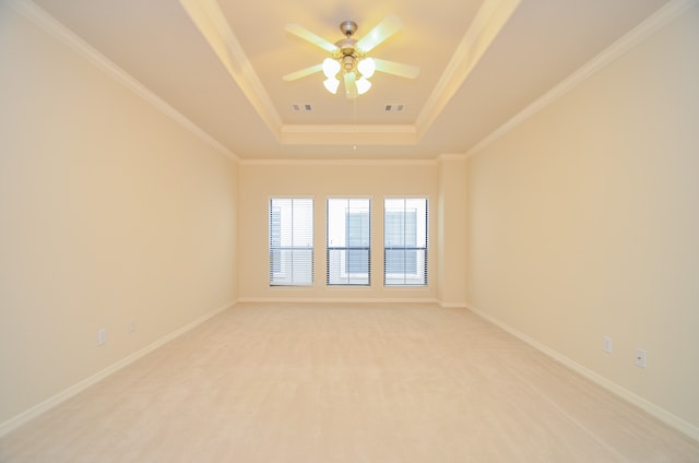 unfurnished room featuring a tray ceiling, ceiling fan, and crown molding