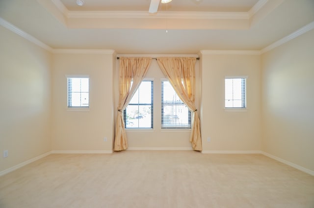 carpeted spare room featuring ceiling fan, a raised ceiling, and ornamental molding