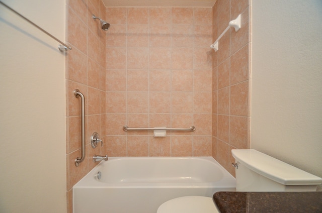 bathroom with tiled shower / bath combo and toilet