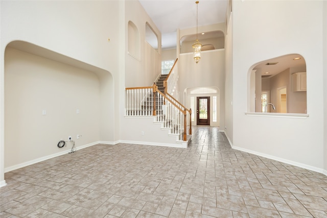 foyer featuring a towering ceiling and sink