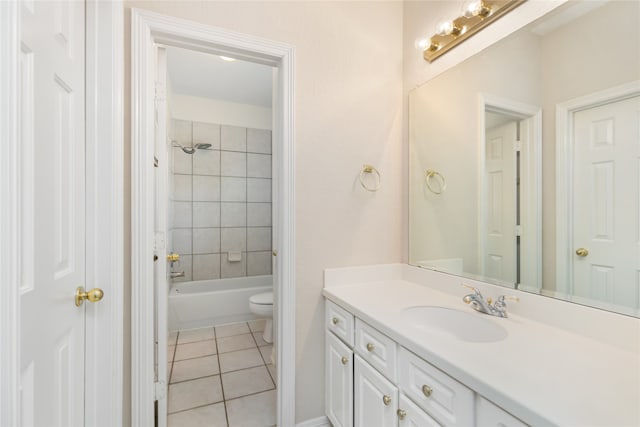 full bathroom featuring tiled shower / bath combo, vanity, toilet, and tile patterned floors