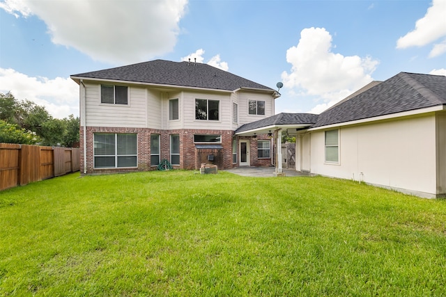 rear view of property with a lawn and a patio