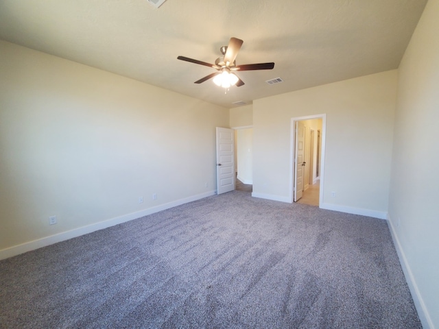 unfurnished bedroom featuring baseboards, visible vents, connected bathroom, a ceiling fan, and carpet