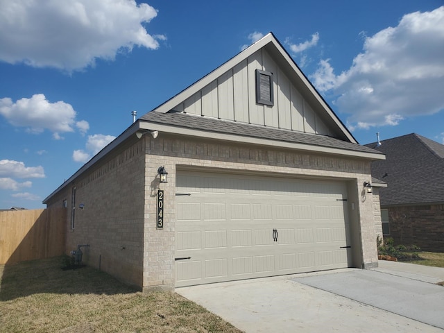 garage with concrete driveway and fence