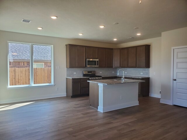 kitchen with dark wood-style flooring, a sink, visible vents, appliances with stainless steel finishes, and tasteful backsplash