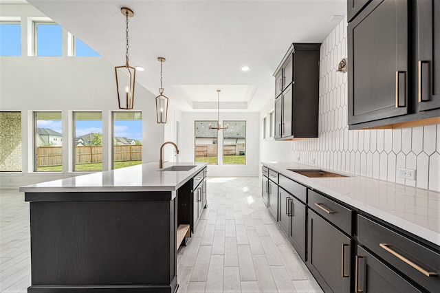 kitchen featuring a healthy amount of sunlight, a kitchen island with sink, and sink