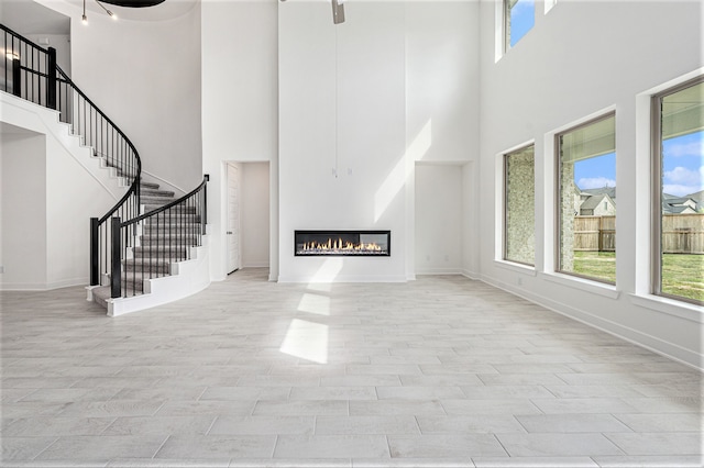 unfurnished living room with a healthy amount of sunlight and a towering ceiling