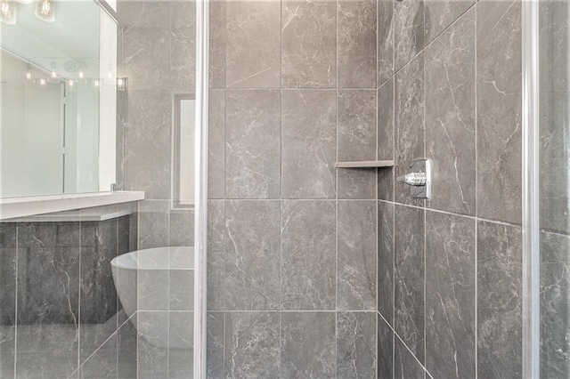 bathroom with tile walls and a shower with door