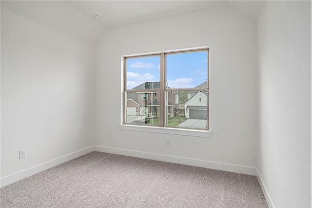 unfurnished room with carpet and vaulted ceiling