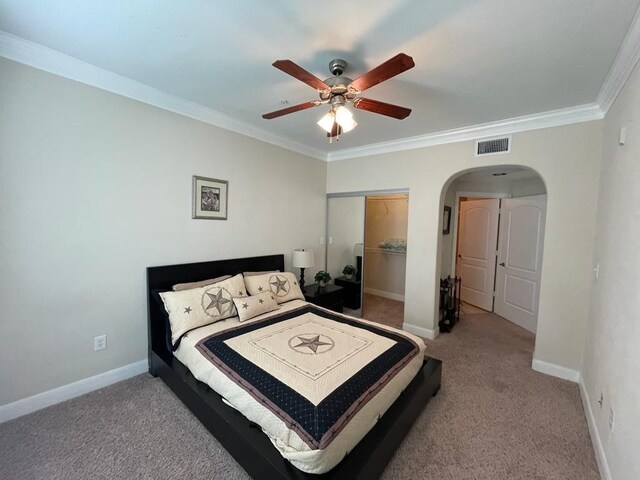 carpeted bedroom featuring a closet, ceiling fan, and crown molding