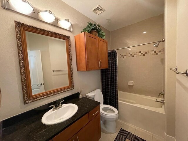 full bathroom featuring shower / tub combo with curtain, tile patterned floors, vanity, and toilet