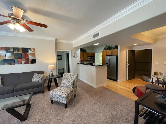 carpeted living room featuring a textured ceiling, ceiling fan, and crown molding